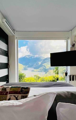 a bedroom with a large window with a mountain view at La Vista EcoHouse in Macanal
