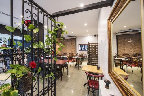 a dining room with tables and chairs and a mirror at Hotel Miño in Ourense