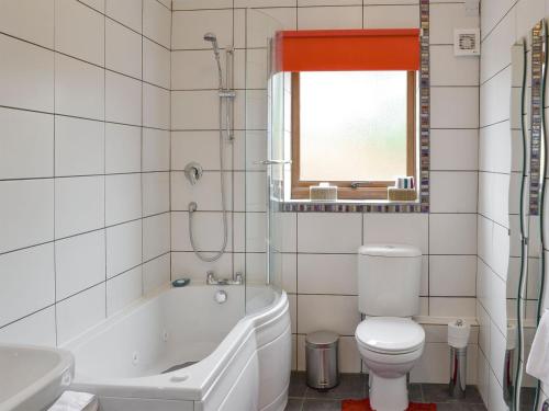 a bathroom with a tub and a toilet and a sink at Spindlestone in Beal