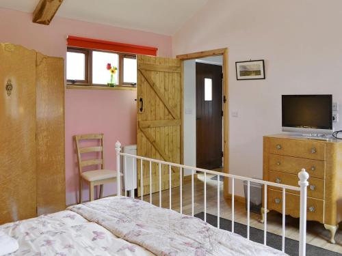 a bedroom with a bed and a tv and a sliding door at Spindlestone in Beal