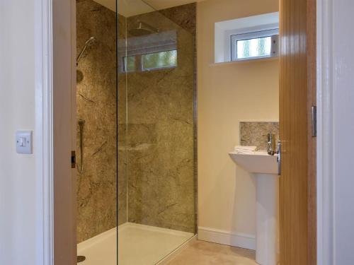 a bathroom with a glass shower with a sink at Rosebank Cottage in Aldbrough