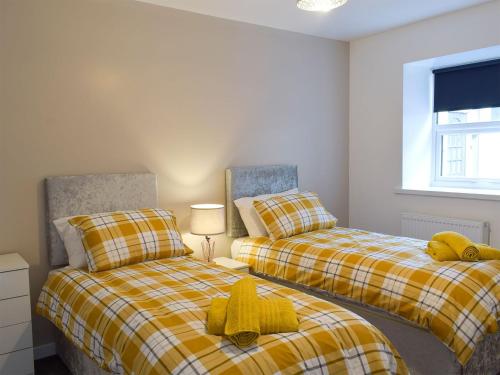 two beds sitting next to each other in a bedroom at East Lodge in Creebridge