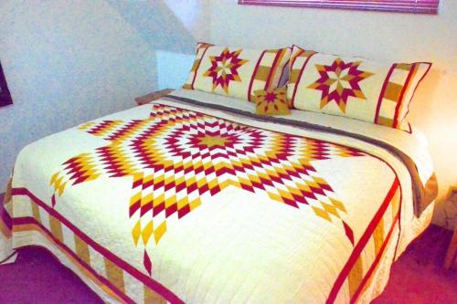 a bedroom with a large bed with a colorful blanket at The Roost Apartment SEDONA'S MOST LOVED in Sedona