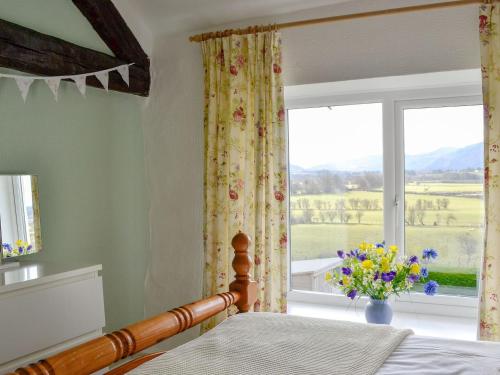 a bedroom with a bed and a window with a view at The Tottsie in Bassenthwaite