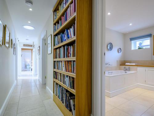 a hallway with a book shelf filled with books at Coach House Cottage in Wotton-under-Edge