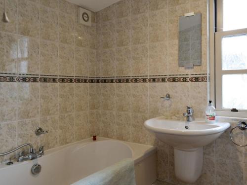 een badkamer met een wastafel, een bad en een wastafel bij Linton in Keswick