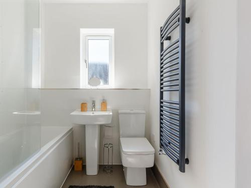 Blackberry Cottage في ستوماركت: حمام ابيض مع مرحاض ومغسلة