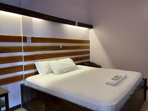 um quarto com uma cama e uma cabeceira em madeira em SKY INN em Caye Caulker