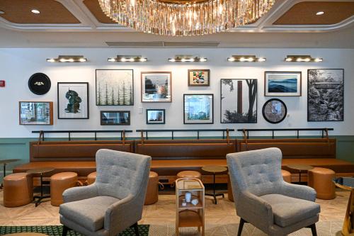 a waiting room with tables and chairs and a chandelier at Six South St. Hotel in Hanover