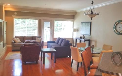 a living room with a couch and a table at Crown Mansion Boutique Hotel & Villas in Qualicum Beach