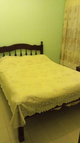 a bedroom with a bed with a yellow bedspread at Casa Cecilia tiene wifi in General Alvarado