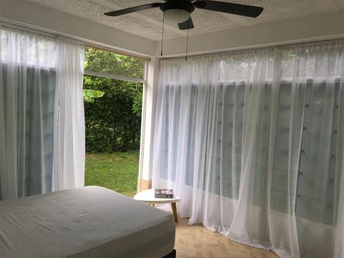 ein Schlafzimmer mit einem Bett und einem großen Fenster in der Unterkunft GRANJA CAMPESTRE EN CONDOMINIO EL GUAMO-TOLIMA in Guamo