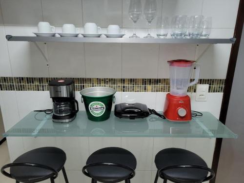a counter with chairs and a blender on it at Couto Lauredo Ap in Rio de Janeiro