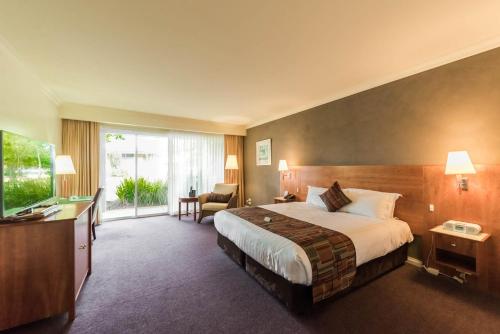 Habitación de hotel con cama y TV en Century Inn en Traralgon