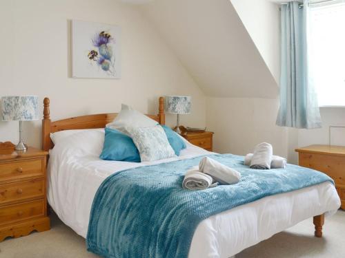 ein Schlafzimmer mit einem Bett mit Handtüchern darauf in der Unterkunft Arthurs Cottage in Edzell