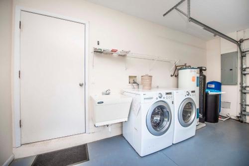 a laundry room with a washing machine and a washer at SWISS 66 - Lake Denise in Clermont
