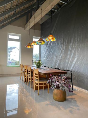 a dining room with a table and chairs and lights at Century House in Da Lat