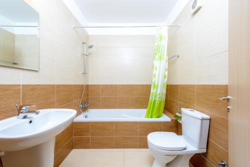 a bathroom with a sink and a toilet and a bath tub at Great Kings Resorts in Protaras