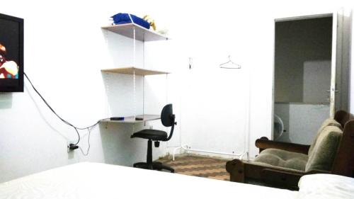 a bedroom with a bed and a chair and a desk at Sobrado Tranquilo Centro in Porto Alegre