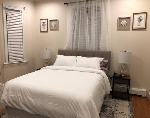 a bedroom with a large white bed and two lamps at Home away from Home! A place to focus and relax! in Cambridge