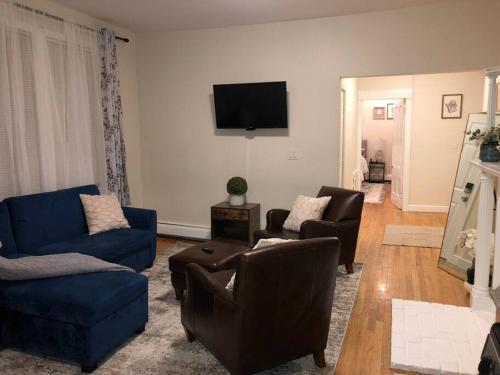 a living room with couches and a flat screen tv at Home away from Home! A place to focus and relax! in Cambridge
