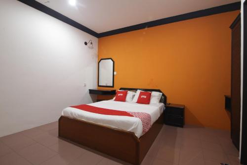 a bedroom with a large bed with red pillows at G CITY HOTEL in Teluk Intan