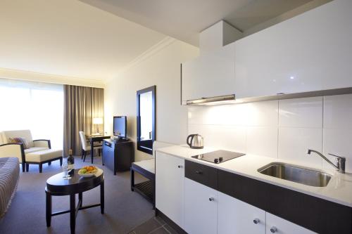 a kitchen and living room with a couch and a table at Century Inn in Traralgon