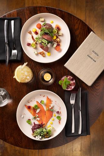 two plates of food on a wooden table at Novotel Auckland Ellerslie in Auckland
