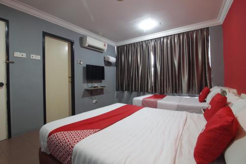 a hotel room with two beds and a window at G CITY HOTEL in Teluk Intan