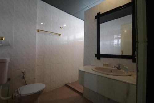 a bathroom with a sink and a toilet and a mirror at G CITY HOTEL in Teluk Intan