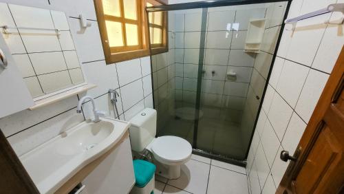 a bathroom with a shower and a toilet and a sink at Brisa do Caitá Praia Hotel in Morro de São Paulo