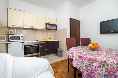 uma cozinha com uma mesa com uma taça de fruta em Apartments Ivan em Srima