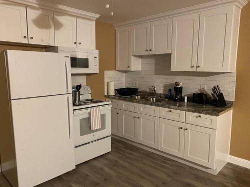 a kitchen with white cabinets and a white refrigerator at #2 bedroom cozy SUITE, 1 min walk to the beach # in Bullhead City