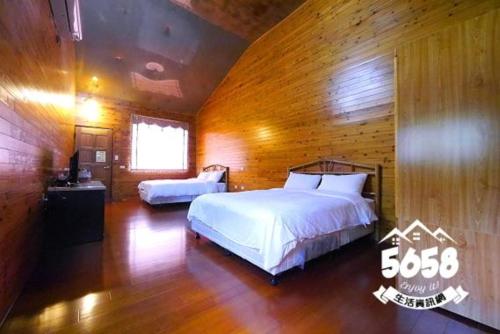 1 dormitorio con 2 camas y pared de madera en Shan Shui Yan Homestay, en Liugui