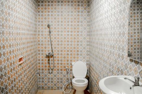 y baño con ducha, aseo y lavamanos. en Residences by RedDoorz near Taman Safari, en Bogor