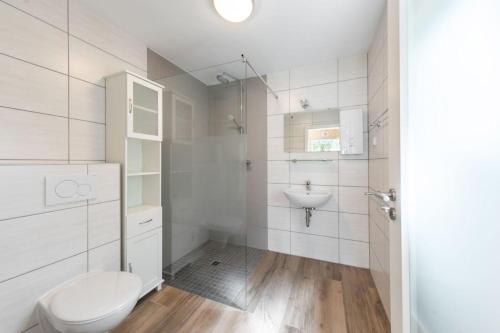 a white bathroom with a toilet and a sink at Ferienhaus 1 - a68756 in Sondershausen