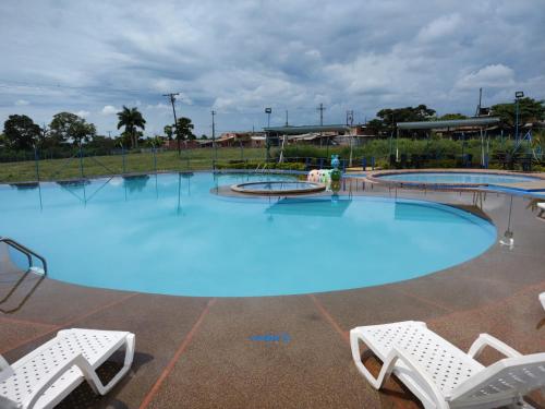 a large swimming pool with two white chairs in front of it at hospedaje del cafe in Montenegro