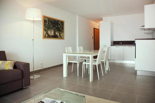 un salon avec une table et des chaises blanches dans l'établissement Apartment in Macinaggio by the Marina, à Macinaggio