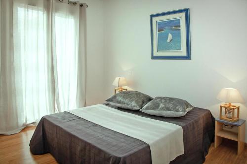 une chambre avec un grand lit avec deux oreillers dans l'établissement Apartment in Macinaggio by the Marina, à Macinaggio