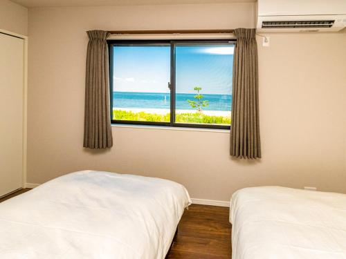 a bedroom with a window with a view of the ocean at T.Square in Akashi