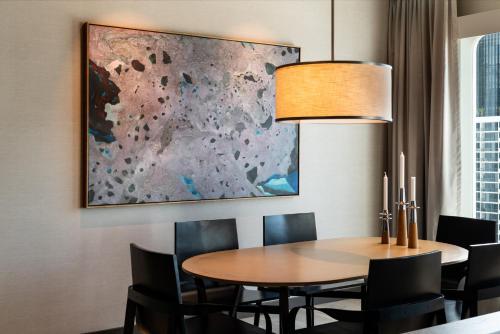 a dining room with a table and chairs and a painting at InterContinental Perth City Centre by IHG in Perth