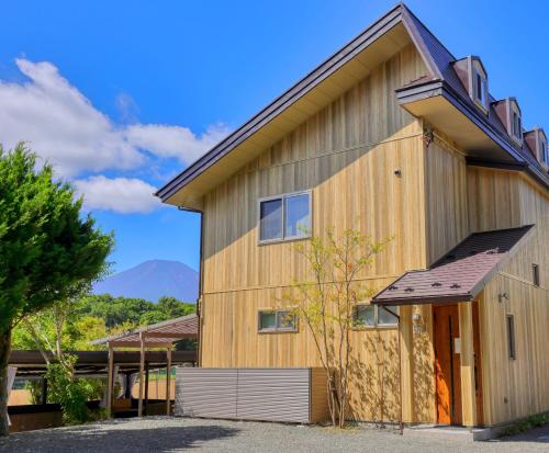 a wooden house with a mountain in the background at SILVER SPRAY MtFuji view Yamanakako in Yamanakako