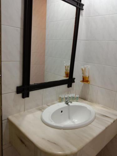 a bathroom with a white sink and a mirror at G CITY HOTEL in Teluk Intan