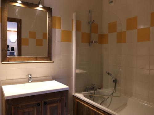 a bathroom with a sink and a tub and a mirror at Appartement Aussois, 3 pièces, 6 personnes - FR-1-508-278 in Aussois