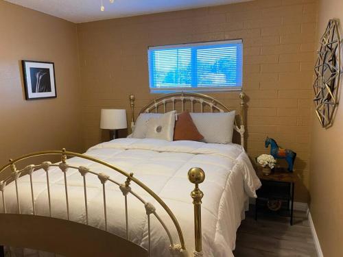 a bedroom with a bed with white sheets and a window at Couples getaway in Bullhead City