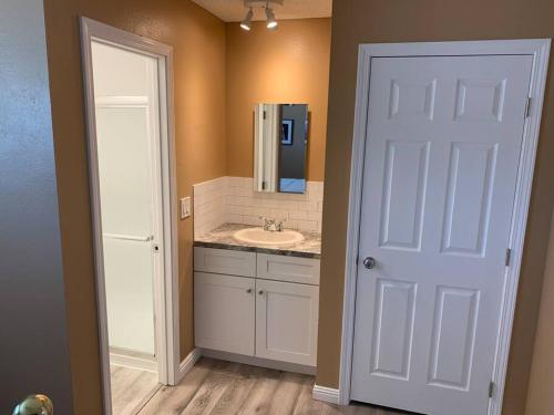 a bathroom with a sink and a white door at Couples getaway in Bullhead City