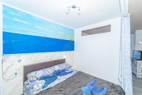 een slaapkamer met een bed met een schilderij aan de muur bij Beach House Tenerife in Costa Del Silencio