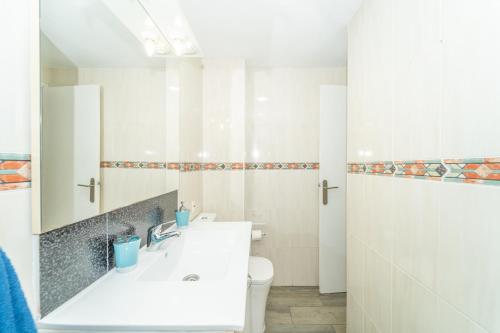 een witte badkamer met een wastafel en een toilet bij Beach House Tenerife in Costa Del Silencio