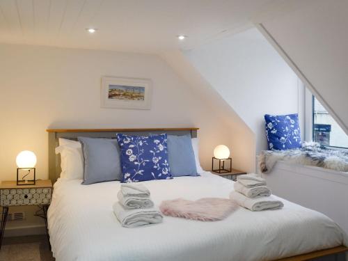a bedroom with a bed with towels on it at Pebble Cottage in Port William
