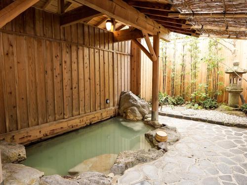 een zwembad met groen water in een houten gebouw bij Hakone Onsen Yuyado Yamanoshou in Hakone